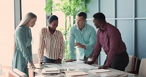 Four happy multiethnic teammates celebrate joint success, share moment, find solution finish group meeting stack their palms together giving high five, gesture of unity, support and synergy. Teamwork