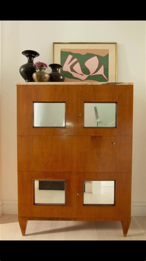 This is a bar that is not all about having a drink, but about enjoying a beautiful 1920s wood cabinet with mirror inserts. #vicentewolf #interiordesign #barcart #woodcabinet