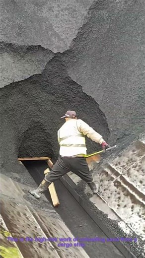 Dangerous Sand Unloading: Man Clears Chute at Cargo Ship