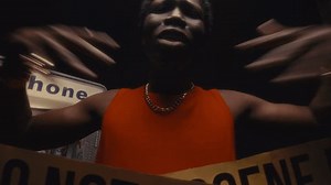 Black rapper performing with intensity behind caution tape at gritty crime scene with street payphone, spitting raw verses with bold gestures directly to camera