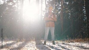 travel navigation. man tourist looking for a way in a smartphone navigation in winter in a forest park. male hacker navigates in the forest navigation looking for a way in winter lifestyle in park