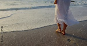 Woman walking on beach during sunset