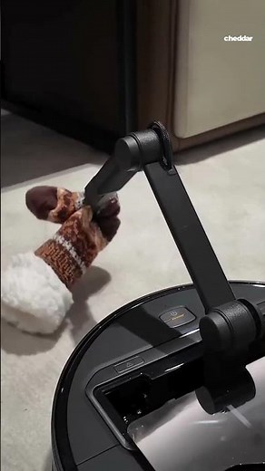 This robot vacuum has an arm that picks up dirty socks