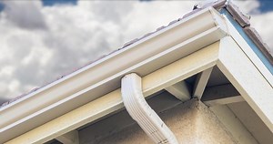 Rain Gutter and Drain Downspout with Time lapse Storm Clouds Behind