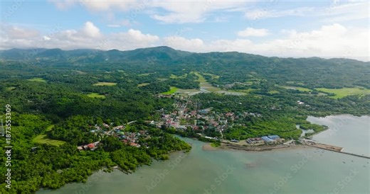 Drone view of Looc Poblacion with residential area at coast and pier. Tablas Island. Romblon, Philippines.
