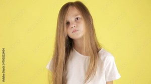 Kids problems. Studio portrait of upset child girl crying and wiping her tears, yellow background.