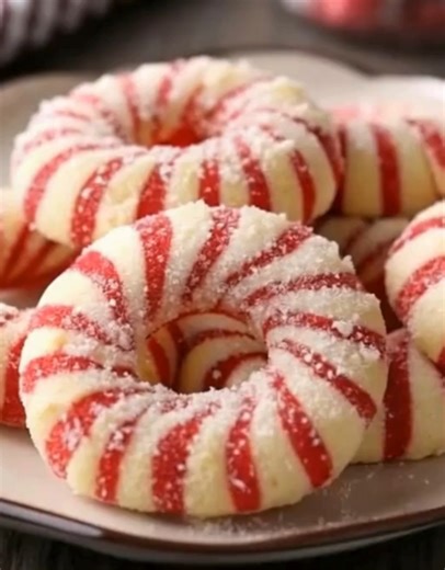 Delicious Candy Cane Cookies You’ll Bake Every Holiday | Buttery, Festive & Sparkly Sweet ❤️🤍 These bring me right back to childhood — baking with Christmas music playing, flour on our noses, and sneaking bites of sugar cookie dough under the table 😄 Ingredients: 1 cup unsalted butter, softened 1 cup powdered sugar 1 large egg 1½ tsp vanilla extract ½ tsp peppermint extract 2½ cups all-purpose flour ½ tsp salt Red gel food coloring Granulated sugar (for rolling) Instructions: Preheat oven to 3