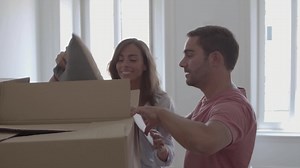 Free stock video - Young couple opening box with pillows and smiling