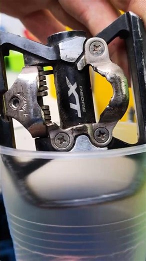 Cleaning a bicycle pedal in an ultrasonic cleaner.