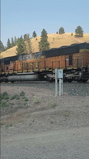 BNSF SD70MAC with MRL mid train DPUs pushing up Mullan Pass.
