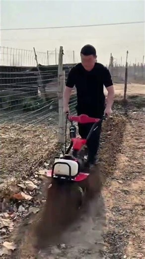 farmer uses motorized tiller to dig a long soil trench