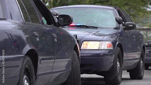 Police vehicles with emergency lights flashing at intersection.