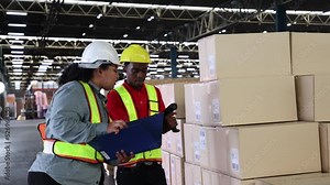 Warehouse worker scanning barcode on box in a large warehouse.