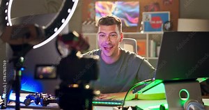 Gaming, computer and man recording for live streaming on social media, podcast and website at night. Influencer, content creator and person with neon for tutorial, broadcast and gamer vlog in home