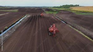 Peat Harvester Tractor on Collecting Extracting Peat. Mining and harvesting peatland. Area drained of the mire are used for peat extraction. Drainage and destruction of peat bogs.