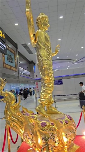 GOLDEN STANDING BUDDHA STATUE IN THAILAND AIRPORT