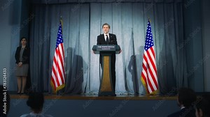 President of USA answers journalists questions, gives interview. American republican politician delivers successful speech to supporters at press conference. Backdrop with American flags. Dolly shot.