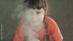 Girl controlling humidity in house. A child try to control the steam from the smart humidifier in the house.