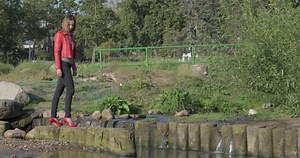 Overconfident woman in high heels shows off and falls down outdoors.