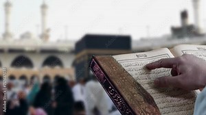 Man Reading Quran in front of the kaaba, Al haram Mecca. Muslim man reading holy Quran facing the holy mosque of kaaba, haram mosque in Makkah, Saudia Arabia. Muslims perform their worship