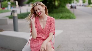 clip-1077640568-happy-young-woman-sitting-on-bench
