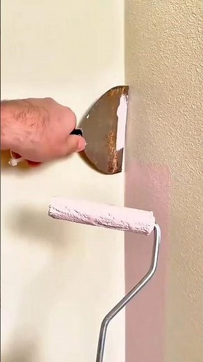 Using a paint roller and scraper to create a clean, straight edge while painting a wall