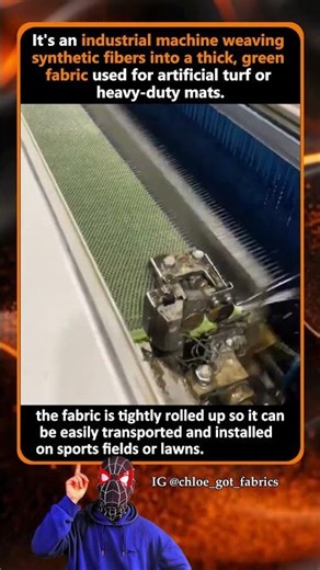 An industrial machine weaving synthetic fibers into a thick, green fabric