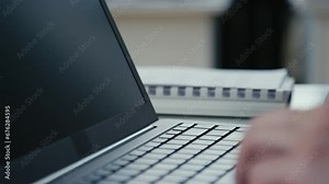 Closeup side shot of male hands opening laptop, waking it from sleep mode and starting work at office
