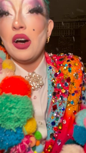 Lolo Brow on Instagram: "1 last month in the snow #lolobrow #drag #switzerland Video description- lolo is a pale drag being. Wearing a suited covered in different coloured pom-poms and large multicoloured rhinestones. They walk through a couple of inches of snow in boots with a bright yellow and blue pompom towards the camera. Snow staying on their quaffed green hair and extra long eyelashes."