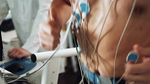 Muscular man athlete running on treadmill in gym for monitoring test his sport performance. Sportsman in sports science lab measuring cardio respiratory, heart check.