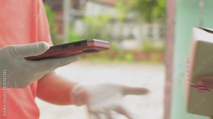 Close up a man hand using smartphone to scan QR code payment for online goods fee. Delivery courier woman wearing rubber gloves holding a parcel for sending to customer at home.