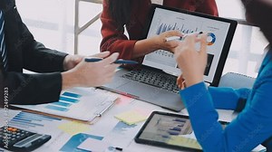 Two creative business people meeting and planning use post it notes sticky note on desk to share idea, Analysis data chart and graph with teamwork strategy brainstorming in office.