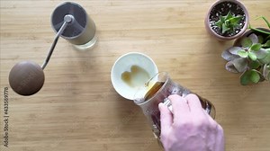 Making coffee. Speciality coffee at home. Barista pours water from the drip kettle into the coffee dripper. Aromatic filter coffee on the table. Ceramic funnel, glass server and filter paper.