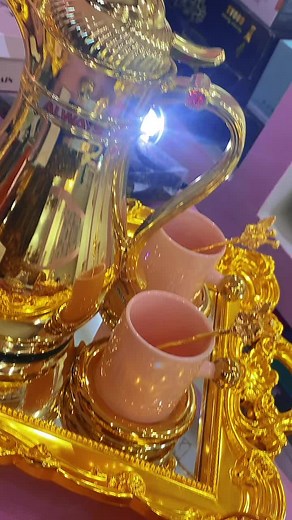Elegant Golden Tea Set Showcase with Pink Teacups
