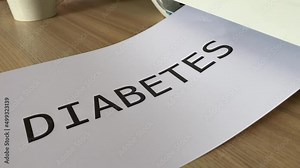 Printing “DIABETES” black text written message word on paper sheet A4 document. Close up page being printed from multifunction printer scanner in office. Hand take paper from printer