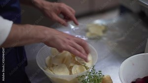 Chef putting fresh rounded organic vegetables like carrots, potatoes and beetroots in plastic bags to vacuum pack and preserve them. Preparing food in a restaurant.