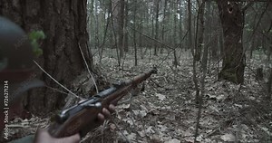 Reenactor Dressed As German Infantry Soldier Shoot From Rifle Carabine Mauser 98k. Combat War Ambush In Forest. Wermacht Military Uniform. Reenactment Combat. Reload And Shooting From Rifle.