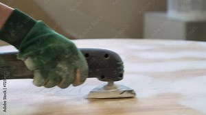 Grinding the surface of an old table with a grinding machine. Furniture renovation, DIY repair, repair by oneself and home improvement