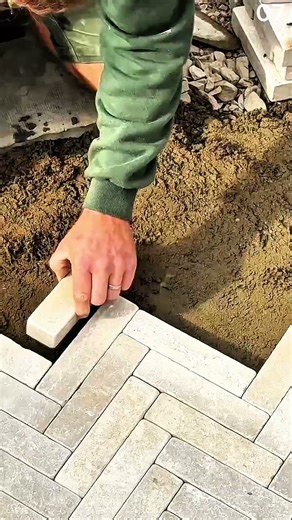 Placing interlocking brick into herringbone pattern gap manually