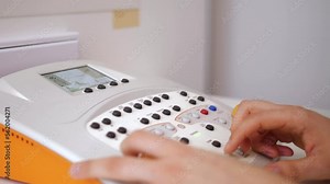 Female audiologist operating hearing test machine during hearing evaluation