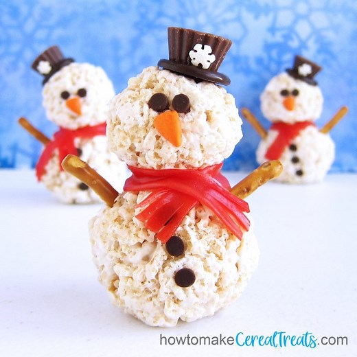 Stay warm inside building these cute Rice Krispie Treat Snowmen. See the recipe here - https://howtomakecerealtreats.com/rice-krispie-treat-snowmen/ | Hungry Happenings