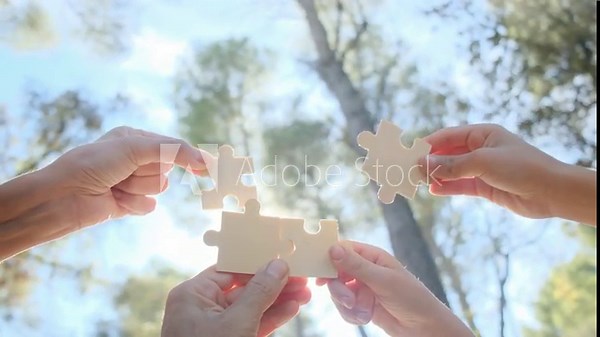Hands of individuals across various age groups coming together to piece a puzzle, embodying the essence of teamwork, cooperation, and effective problem-solving. Witness the power of collaboration.