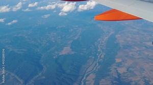 passenger’s perspective from generic airplane’s wing view, flying high above rugged mountain range, providing scenic passenger perspective aerial view aviation plane aircraft flight sky