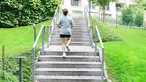 Young woman running up the stairs training workout exercise jogging on steps in city park