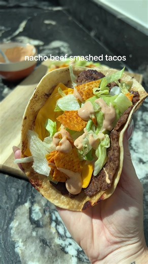 Nacho beef smash tacos 😍 Taco seasoned beef smashed into crispy mini topped with cheese, lettuce, crushed tortilla chips, guac and chipotle sauce 🤌🏻 ‼️Fully inspired by the smashed cheeseburger tacos from my cookbook “Low-Cal Kitchen Bangers” (pg 89). Hit the link in my bio if you fancy giving those a go 🫶🏼 Ingredients (serves 2 (2 wraps each)): 250g 5% fat lean beef mince 1 tbsp taco seasoning Salt & pepper to taste 4 mini tortilla wraps 4 light cheesy slices 70g shredded lettuce 50g store