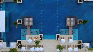 Pool area in luxury hotel, vacation resort, top down aerial view of poolside with sunchairs, shades and bar Stock Video