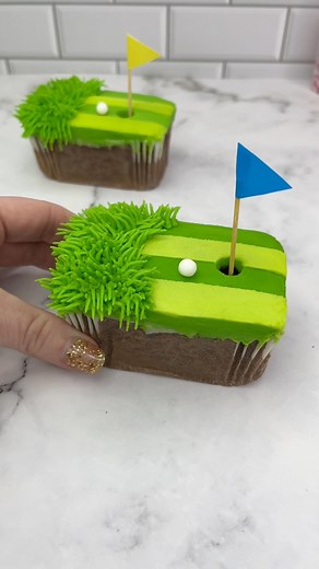 Fancy a round of golf? ⛳️ 💚Made especially for Wilton Cake Decorating using their mini loaf pan, gel colours and piping tips. ⛳️ Bake chocolate cake batter in mini loaf tins.⛳️Use an offset spatula to spread a layer of green buttercream over the top.⛳️Cut 1cm this strips of parchment paper and add one across the top and one across the middle.⛳️Spread a thin layer of lighter green buttercream over two thirds of the cake.⛳️Peel off the parchment. ⛳️Use tip 233 and the darker green bc to pipe gras