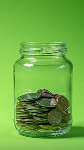 Time lapse of money coin in glass bottle growing growth saving money. Concept financial business investment. Green background. Vertical footage