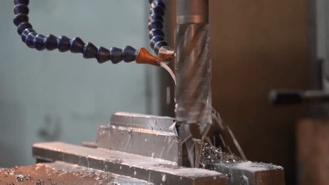 clip-3958430813-cnc-machine-drilling-metal-block-coolant-spray