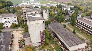 Empty factory caused by the world crisis. Abandoned buildings of industrial plant. Old brick buildings and warehouses. Camera rising.